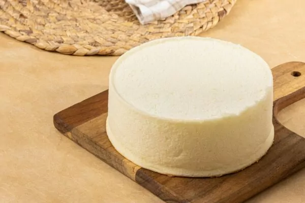 A cheesecake sitting on top of a wooden cutting board